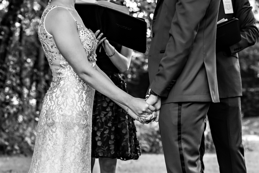 A bride and groom holding hands during their wedding ceremony at Alverthorpe Manor.